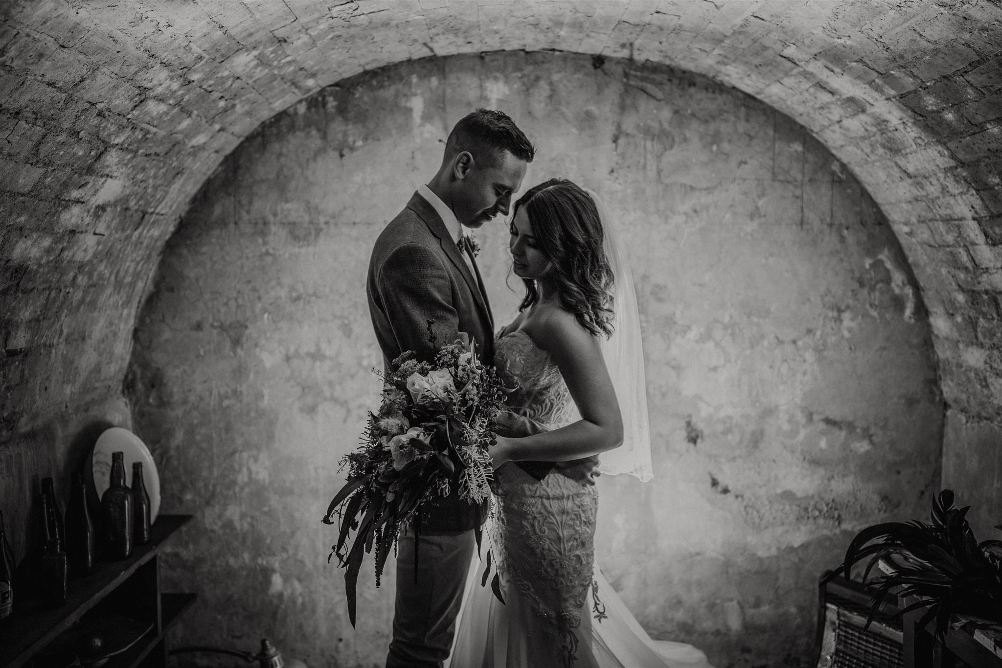 A bride and groom in the wine cellar of woodland estate have a quiet moment on their wedding day captured by Tashina Narelle Photo + Video