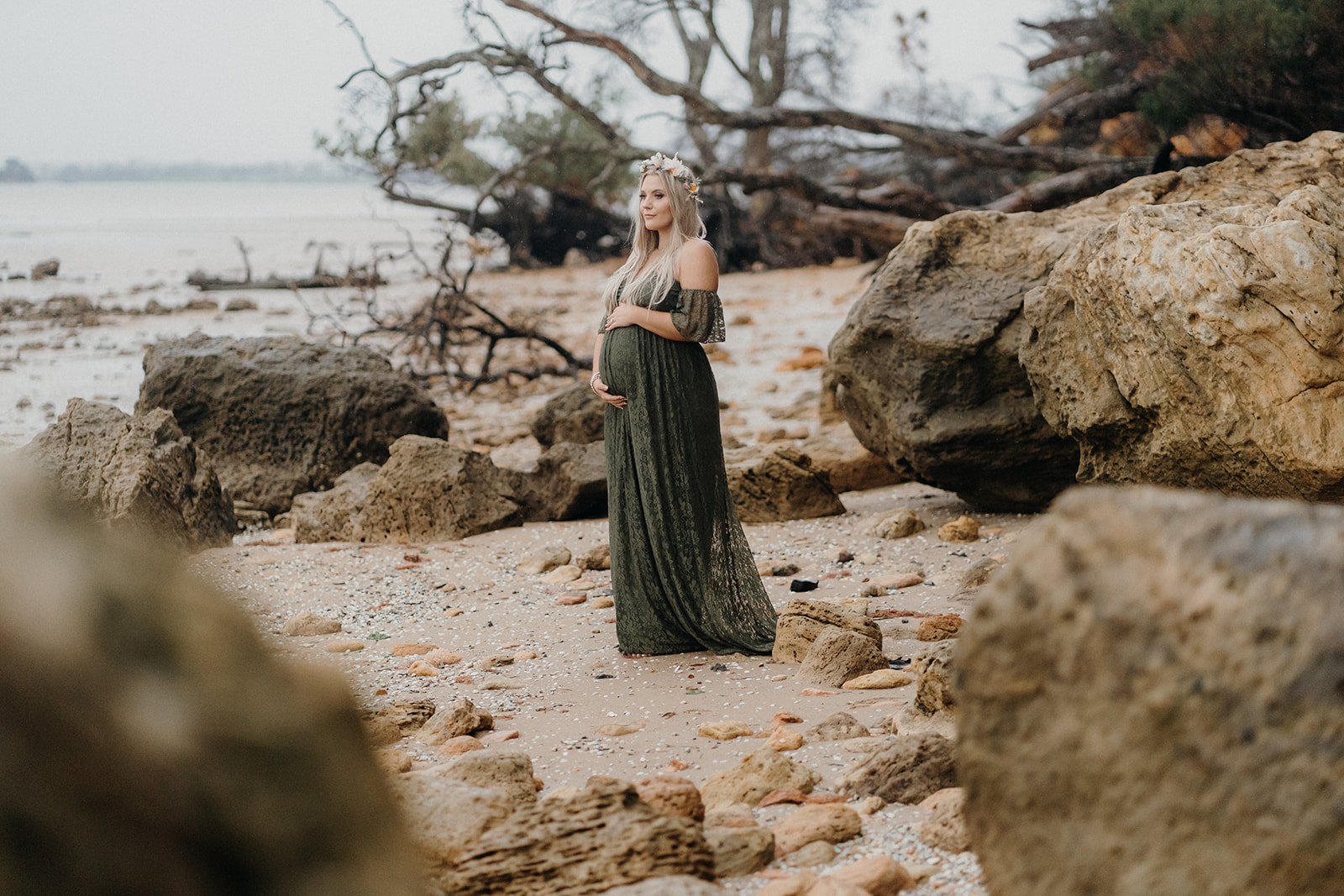 A pregnant lady stands on a beach in Awhitu during her maternity photoshoot